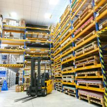 forklift in warehouse full of pallet jacks